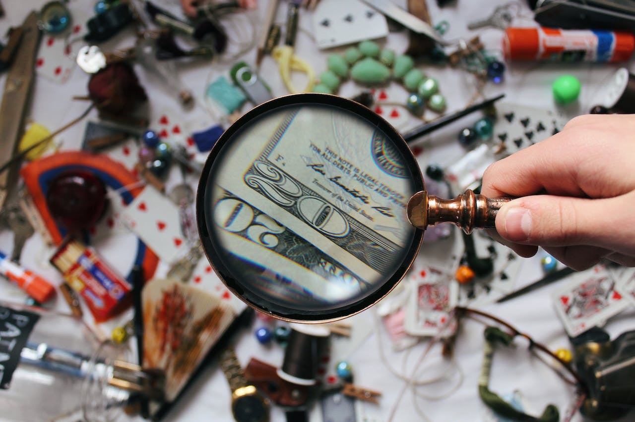 magnifying glass looking through key features of currency, signifying things product managers should pay attention too