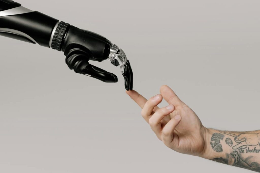 Picture of a robot AI hand touching a human finger with the tip of its finger