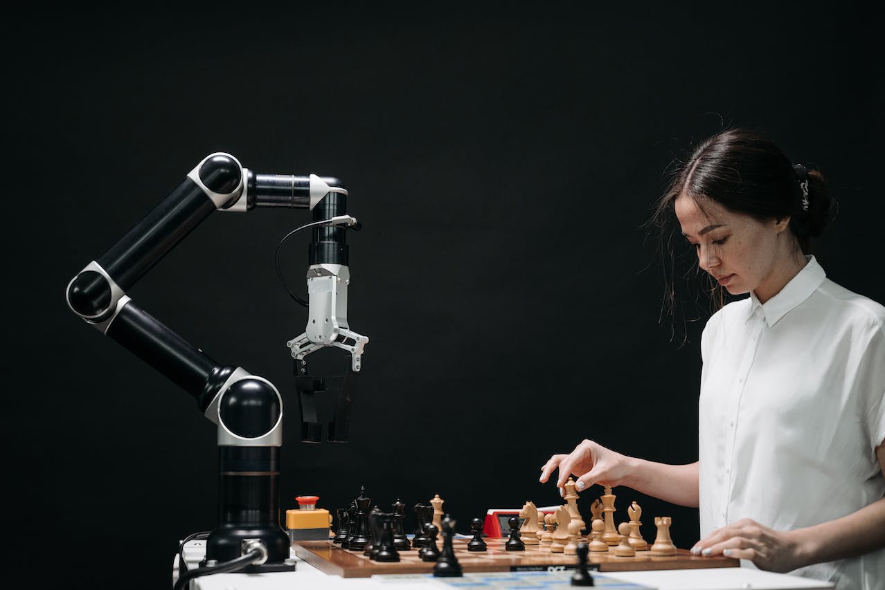 image f a girl playing chess against a prototype robot arm