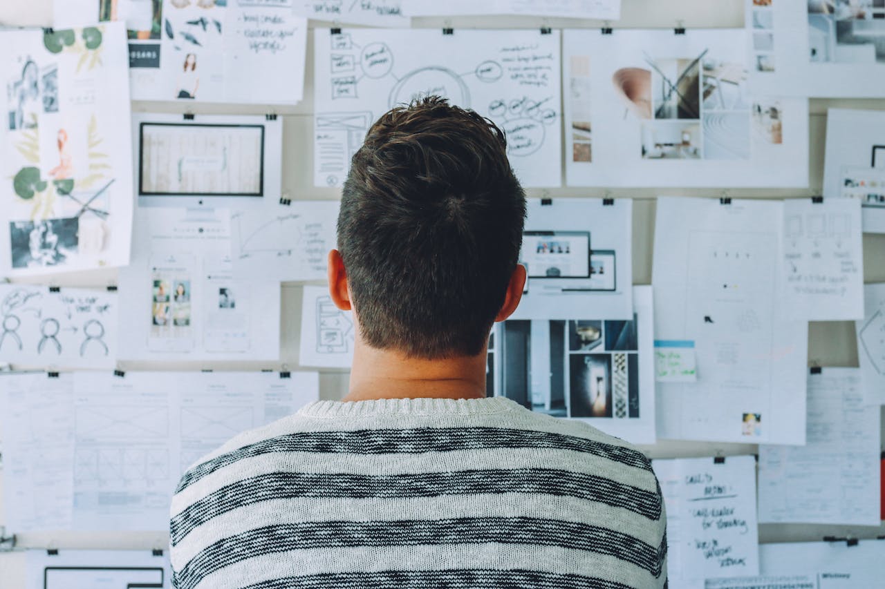 Man looking at a wall full of papers showing data around segmentation