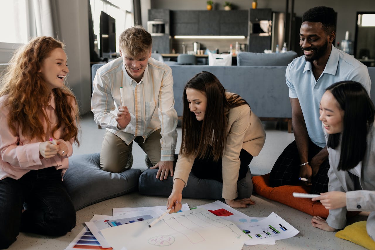 group of people surrounding and smiling at document paper showing segmentation data 