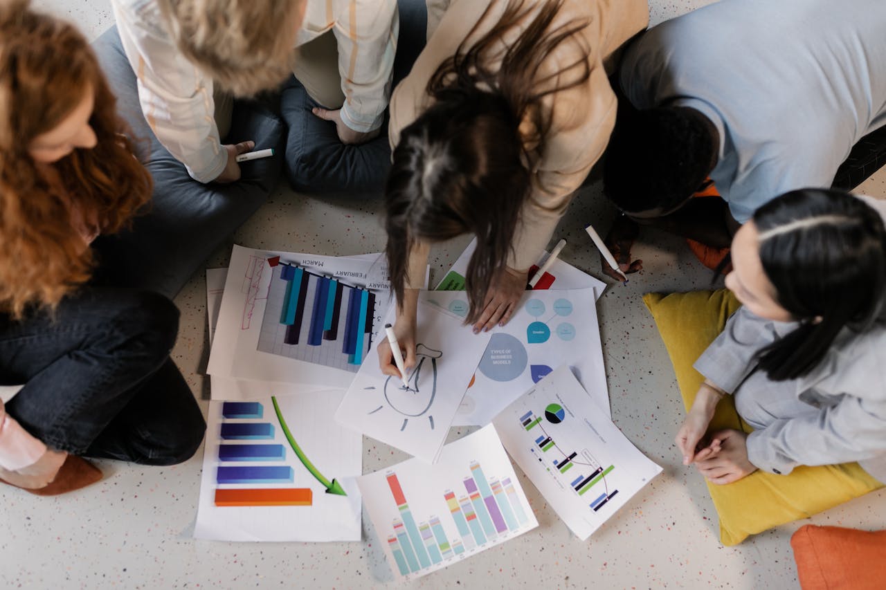 group of people surrounding piece of paper showing segmentation data for branding