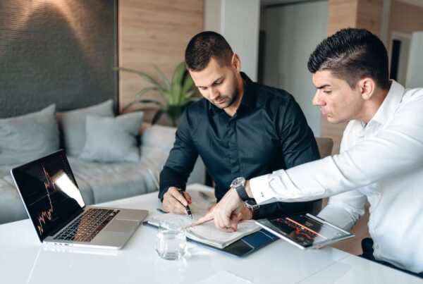image of man 2 men in black discussing their findings
